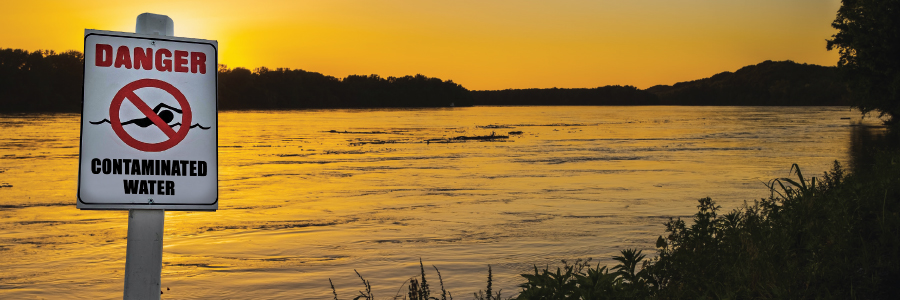 Image of a lake with a "Danger Contaminated Water" sign
