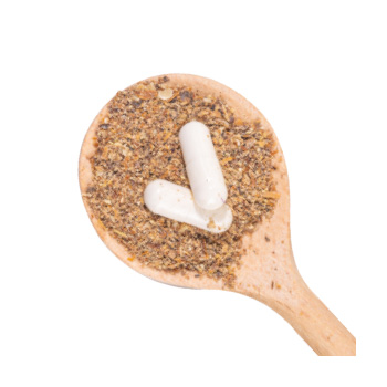 Image of a wooden spoon with herbs and capsules