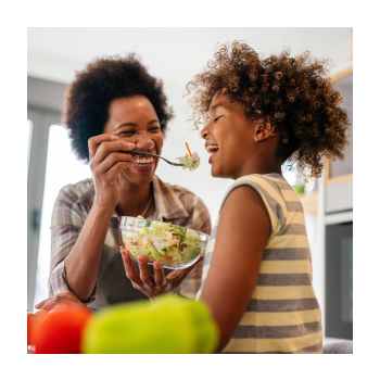 Parent feeding child salad